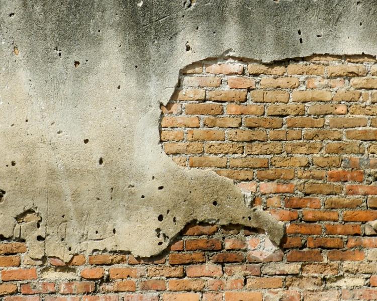 Muro descascando, deixando aparentes os tijolos