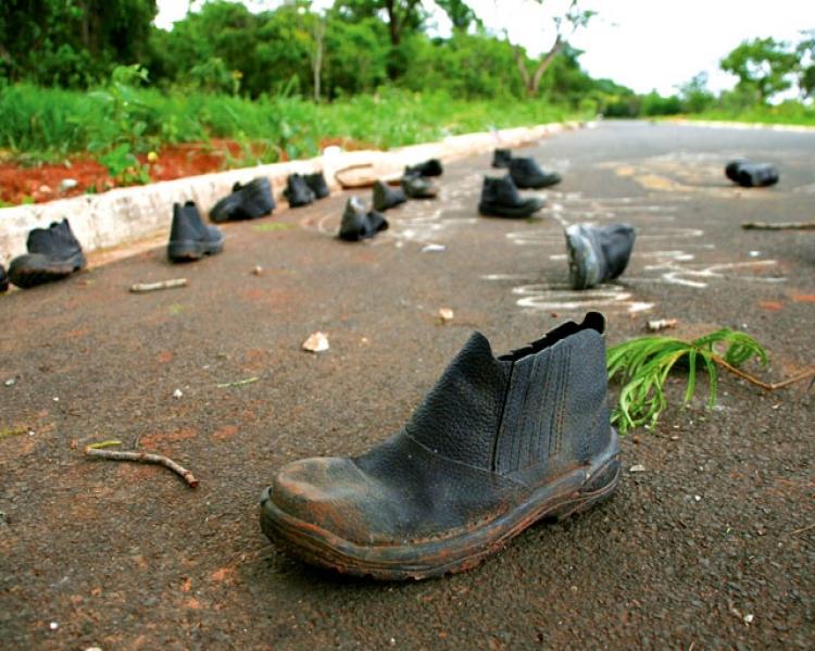 Botas pretas, abandonadas numa estrada 
