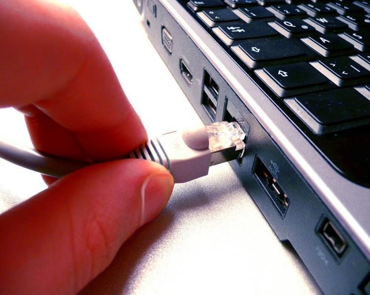 dedos plugando um cabo de internet