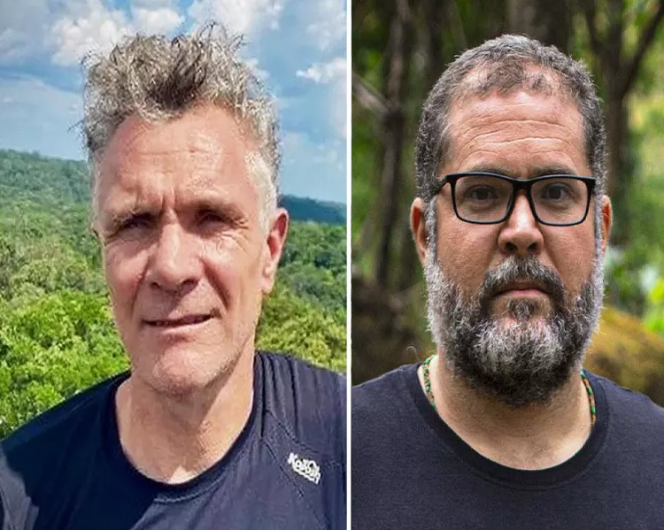 Dois homens, lado a lado, com camisetas de tom azul, um de cabelos grisalhos, outro de barba e óculos
