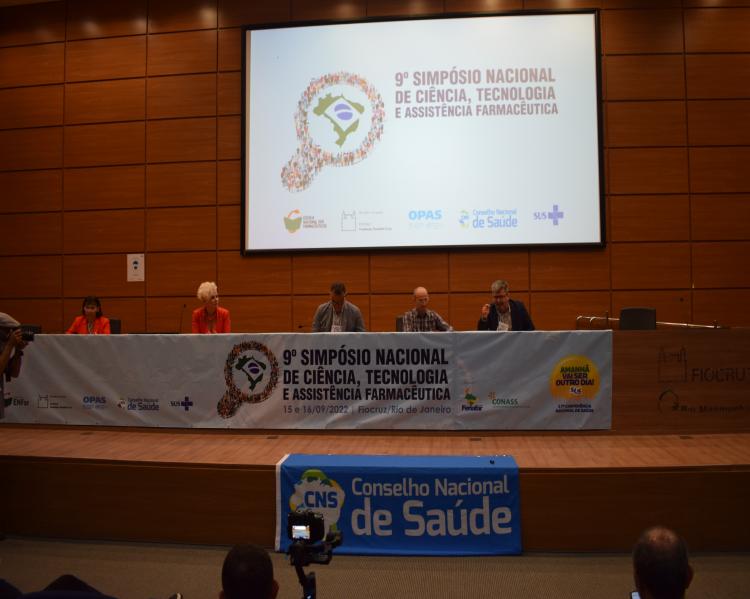 Mesa de debates em que estão sentados lado a lado duas mulheres e três homens