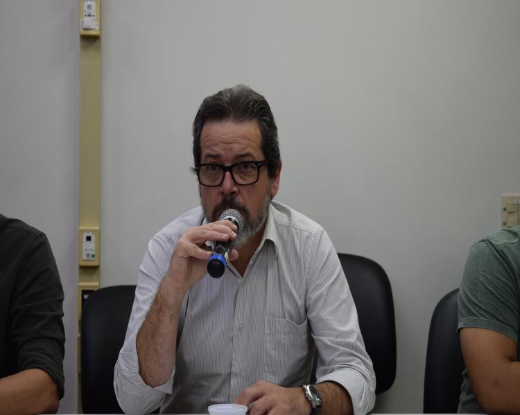 Homem fala ao microfone